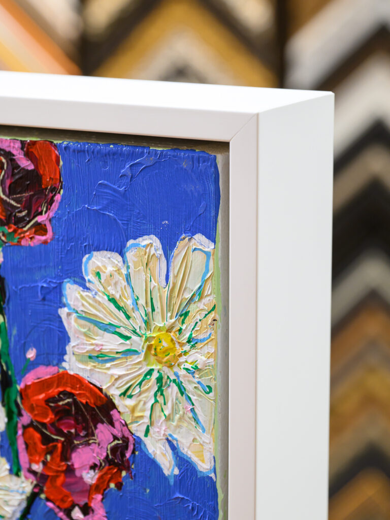 Still life canvas painting framed in a white floater frame at Underglass Custom Picture Framing in San Francisco