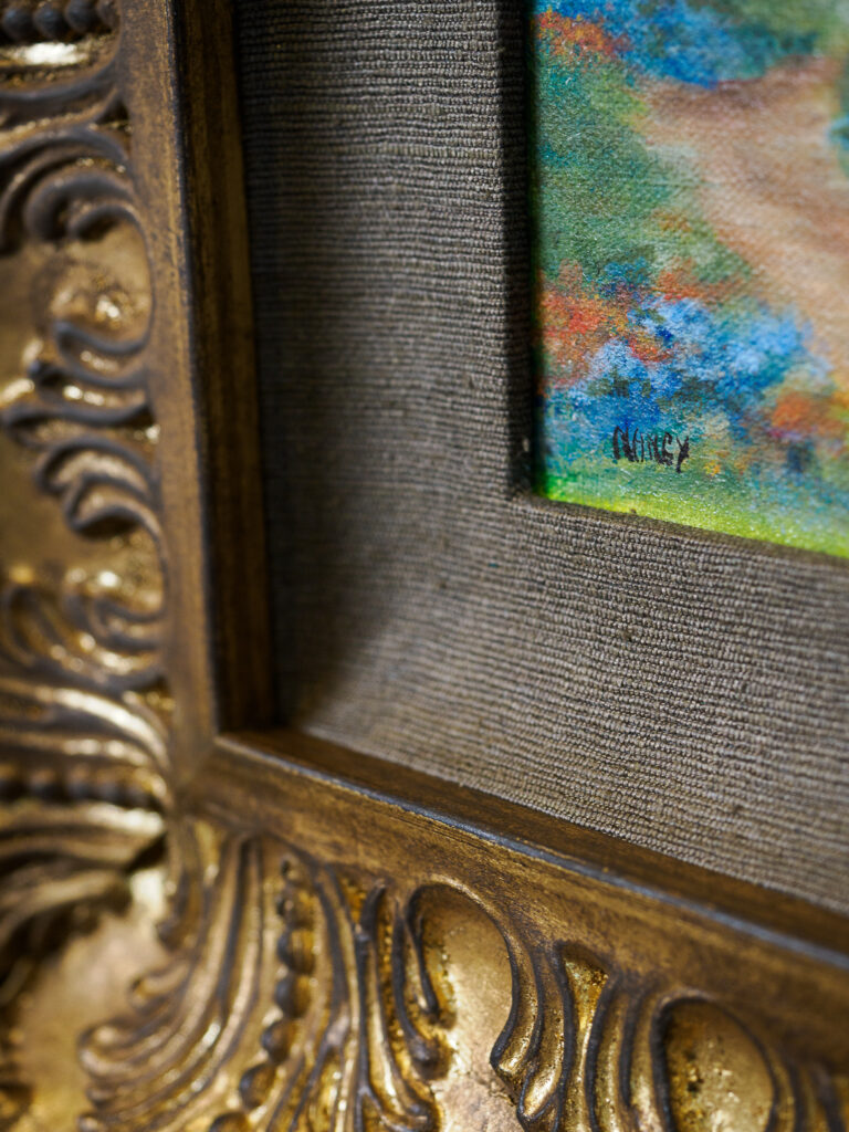 Handwrapped brown fabric liner detail bridging canvas texture and ornate frame, conservation framing San Francisco

