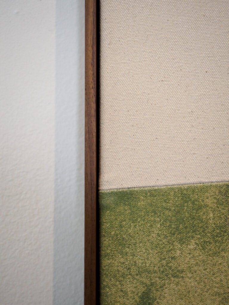 Close-up of natural walnut floater frame gap and textured canvas edge, custom picture framing San Francisco Underglass
